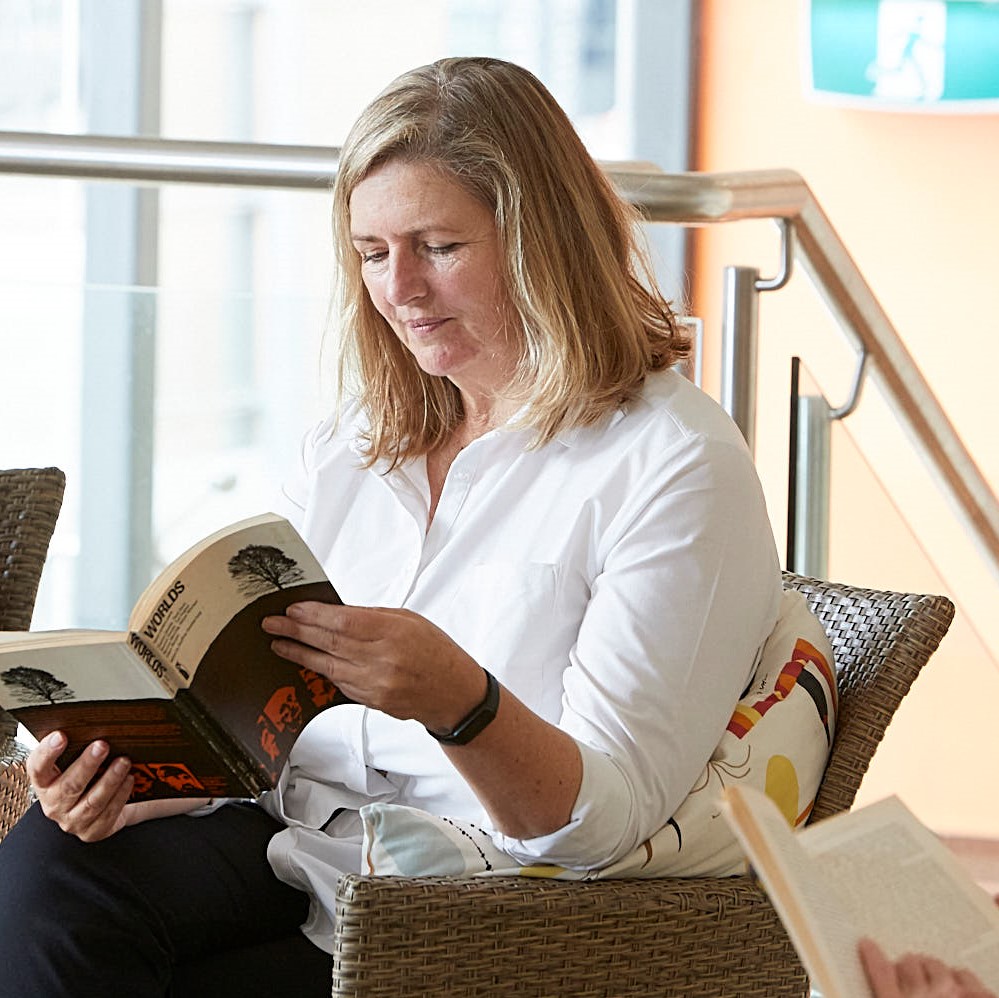 Woman sitting in a chair reading a book